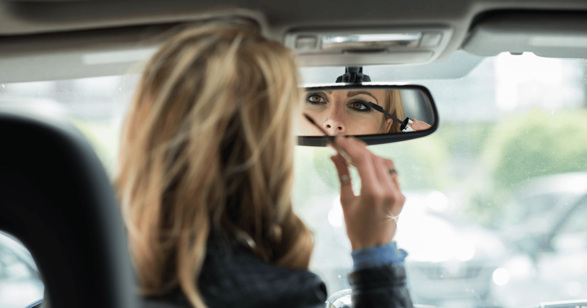 woman applying brows in a car