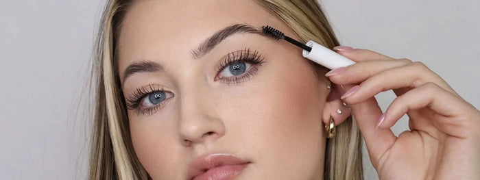 a girl applying brow gel on her eyebrows