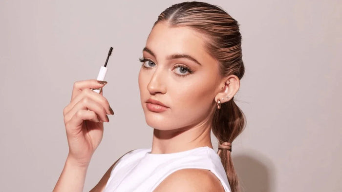 Woman holding brow gel